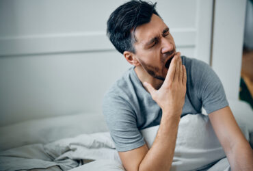 Knirscherschiene, Mann im Bett hat Kieferschmerzen